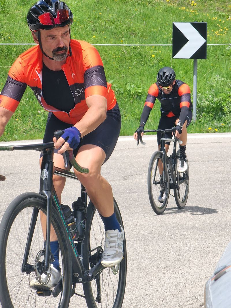 Two riders in PeaksPal kit working up a climb